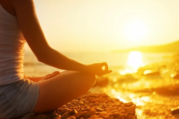 A person is sitting in the sun on rocks