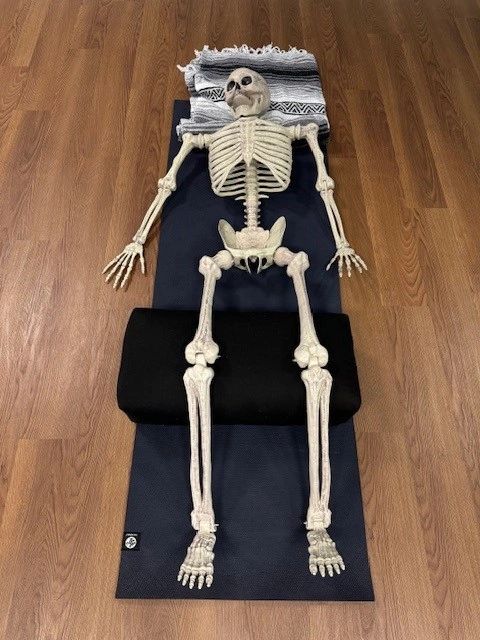 A skeleton laying on top of a mat.