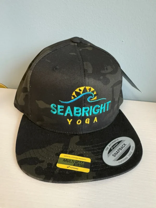 A black hat with the word " seabright yoga ".