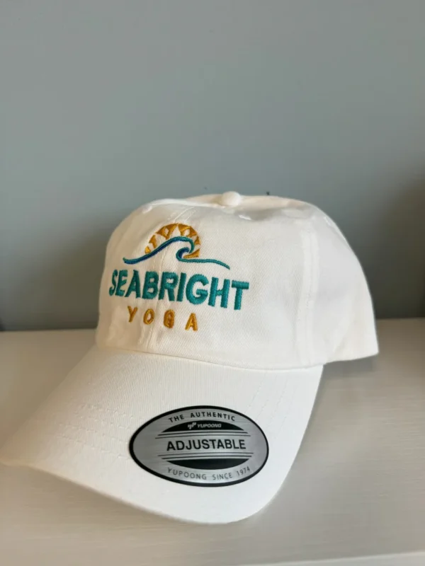 A white hat with the words " seabright yoga ".