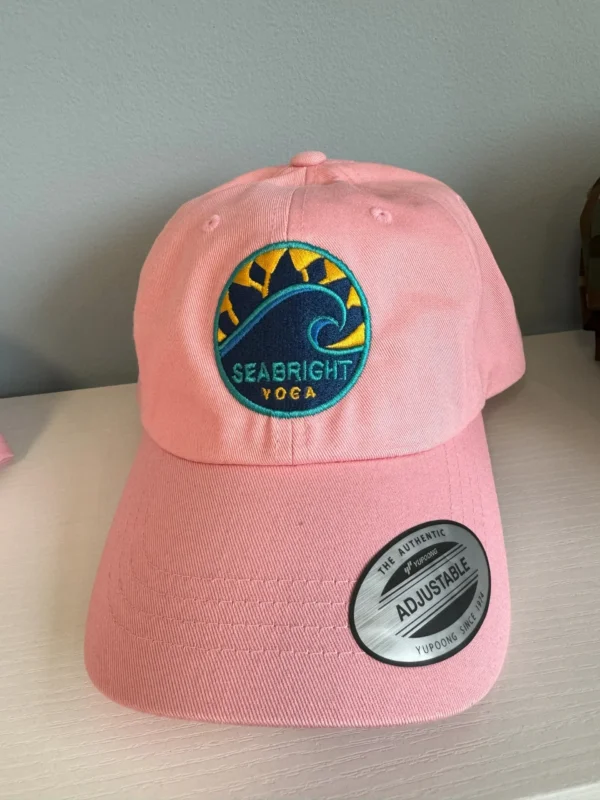 A pink hat with a sea bright logo on it.