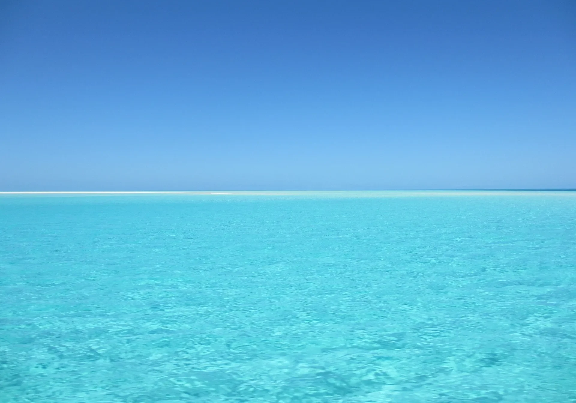 A large body of water with blue sky in the background.